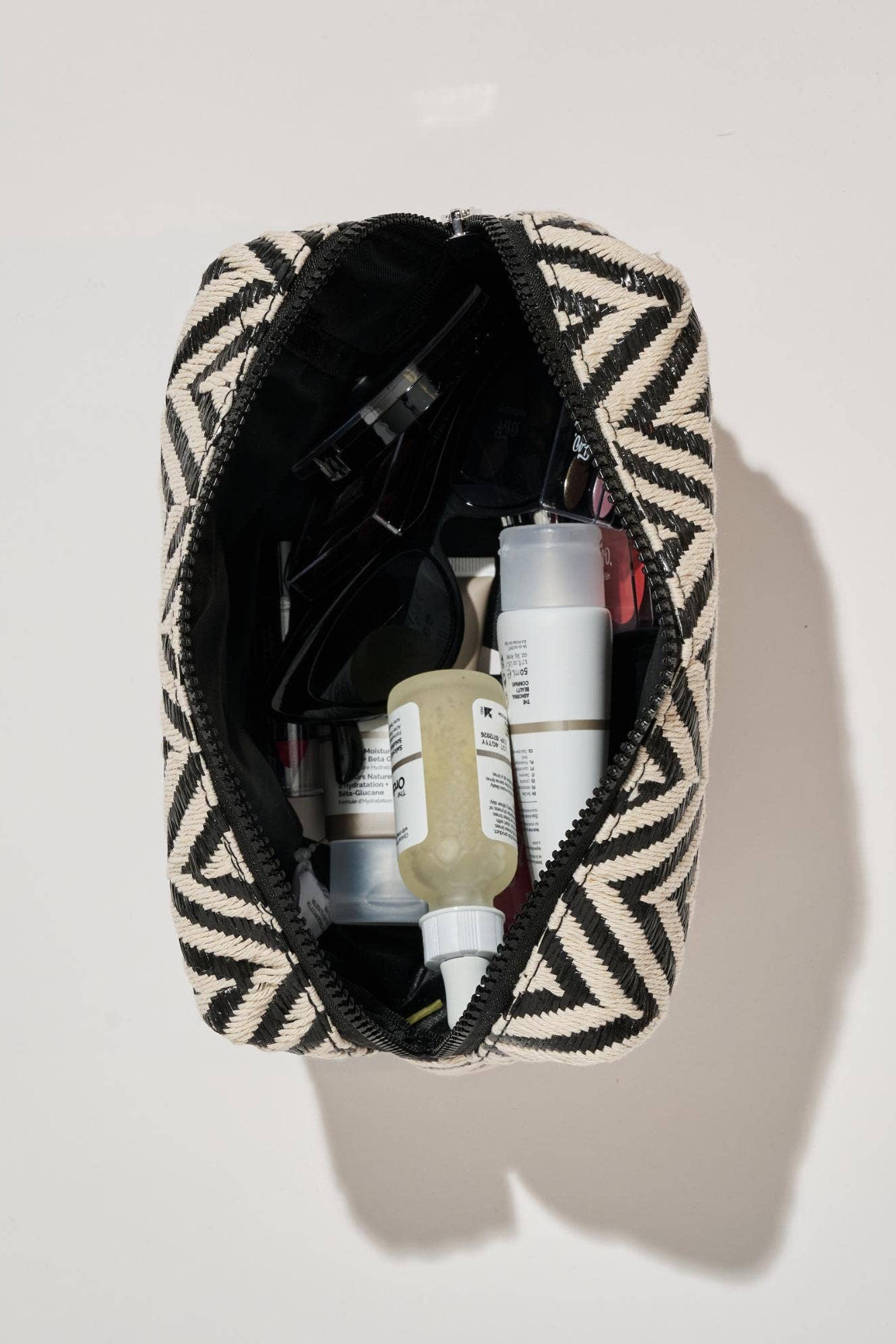 Patterned toiletry bag with personal care items on a light background