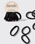 A pack of black Kit-Sch seamless hair elastics with a cardboard header, shown alongside several loose oval-shaped black elastics on a light gray background.
