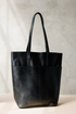 Black leather tote bag on a neutral background