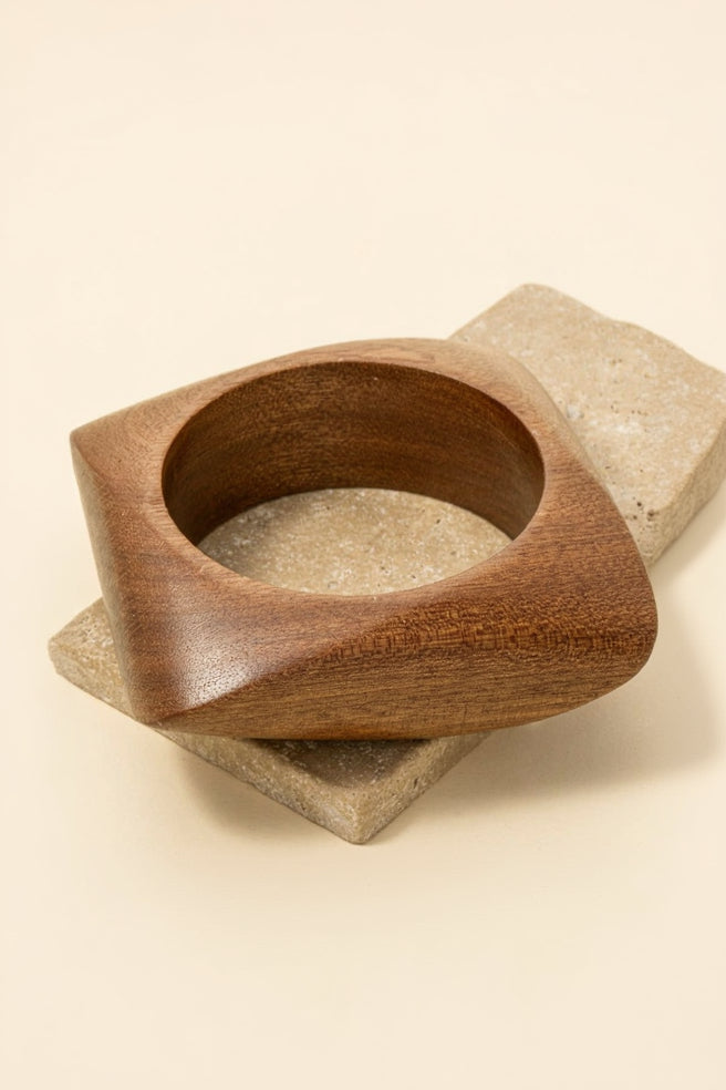 Wooden bowl on a stone surface with a beige background