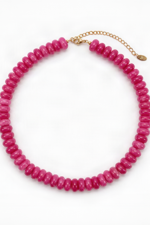 A chunky beaded necklace made of faceted hot pink beads, completed with a delicate gold chain extender and clasp, shown on a plain white background.
