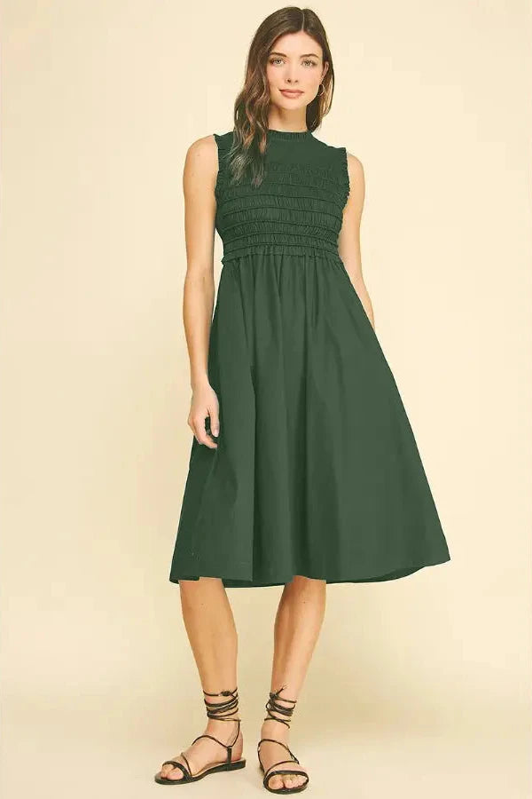 Woman wearing a green dress on a beige background