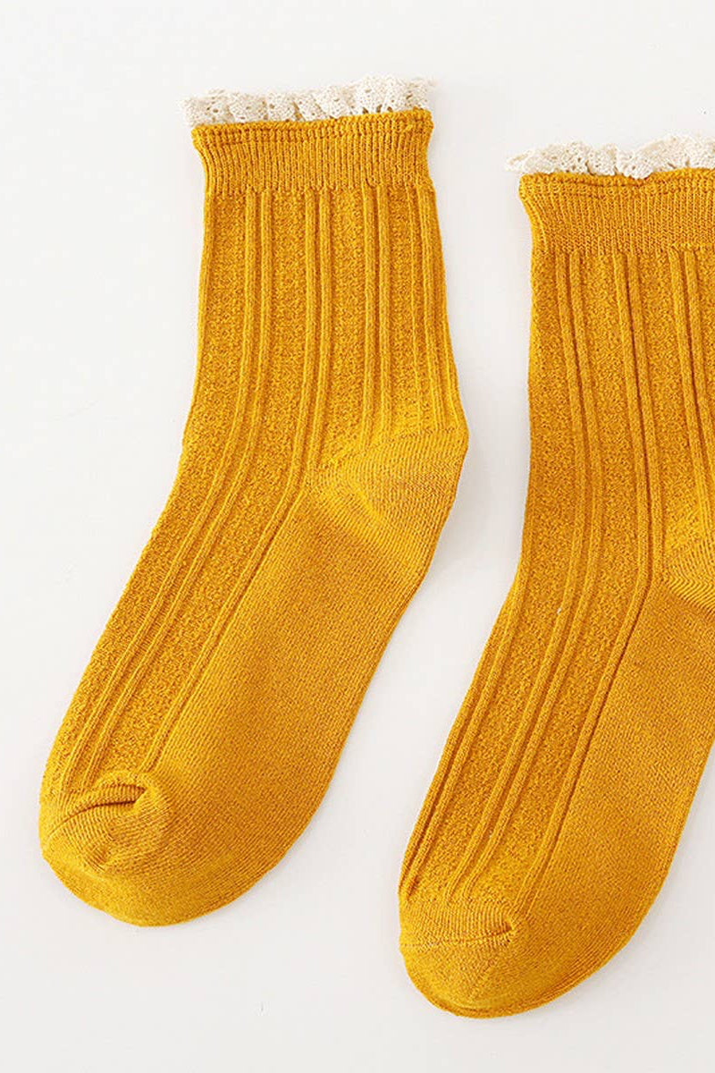 Pair of mustard yellow socks with lace trim on a white background