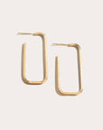 Gold hoop earrings on a light beige background
