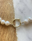 Pearl necklace with a gold clasp on a marble surface