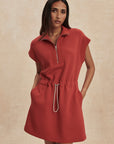 Woman wearing a red dress with a beige background