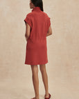 Woman wearing a red dress against a beige background