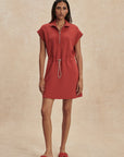 Woman wearing a red dress against a beige background