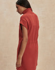 Woman wearing a red dress against a beige background