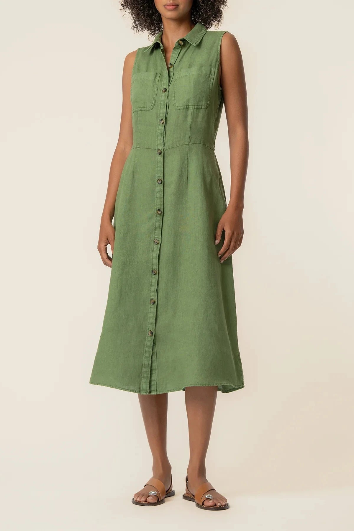 Woman wearing a green dress against a beige background