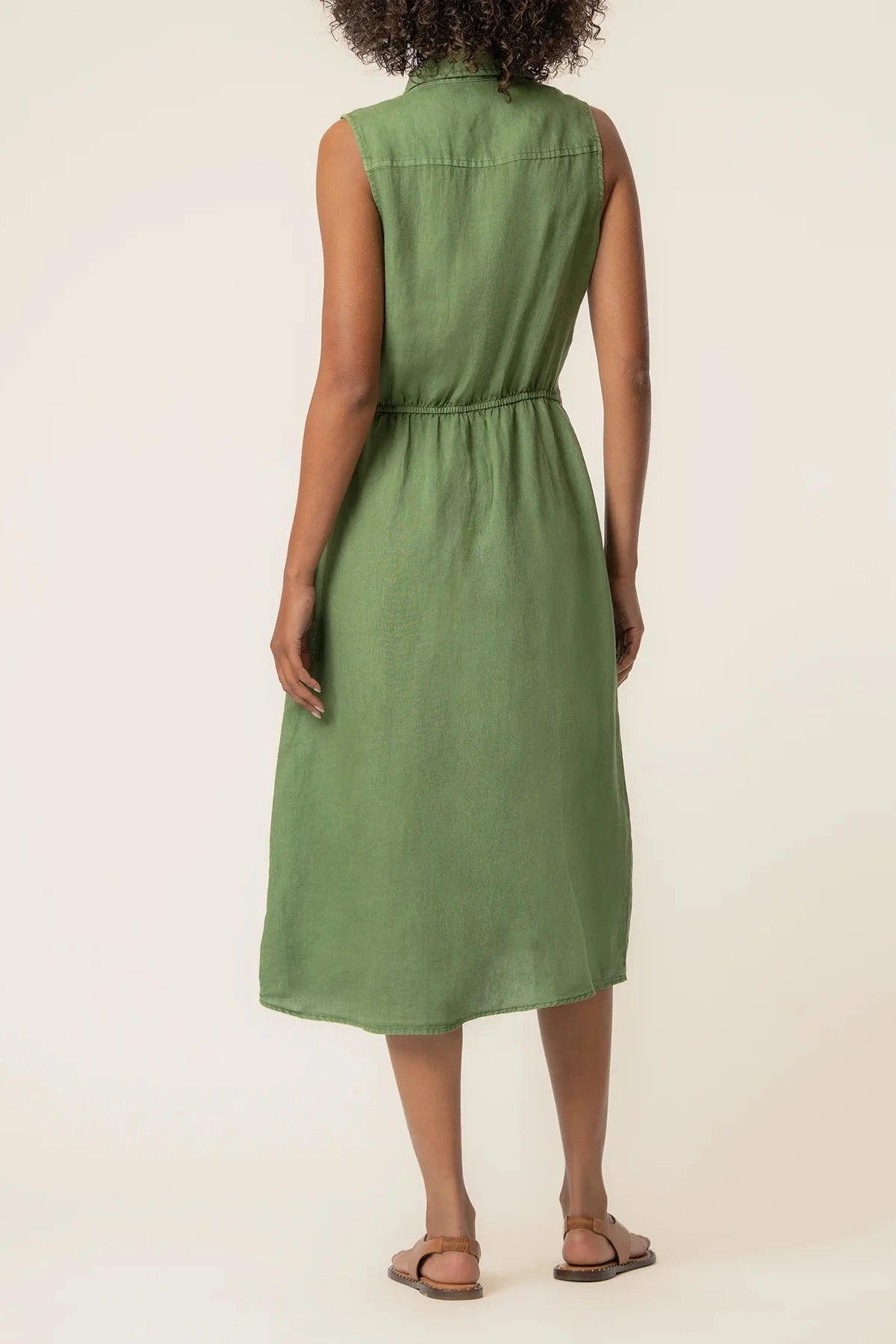 Person wearing a green dress on a beige background