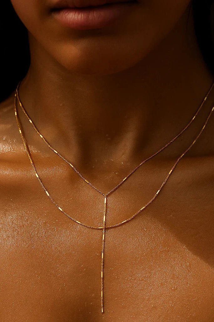 Gold necklace on a person's neck with a blurred background