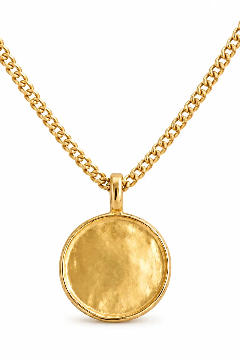 Gold necklace with a round pendant on a white background