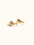 A pair of chunky gold-colored hoop earrings with textured edges, displayed against a white background.