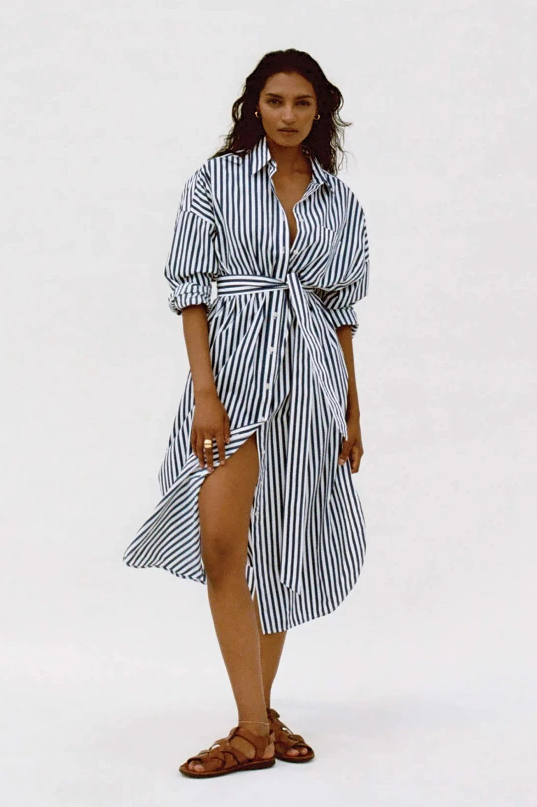 Woman wearing a black and white striped dress on a white background