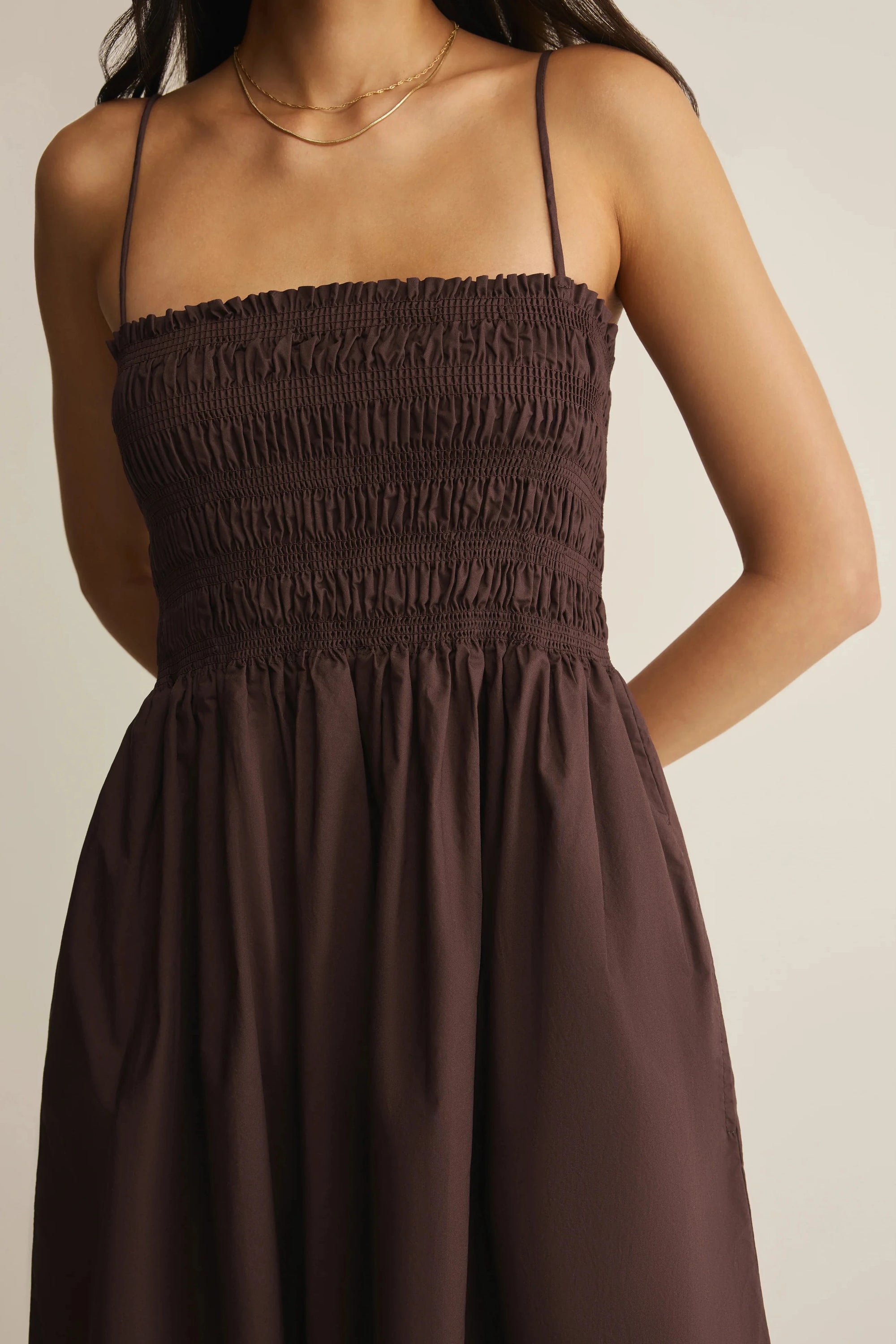 Brown dress worn by a person on a plain background