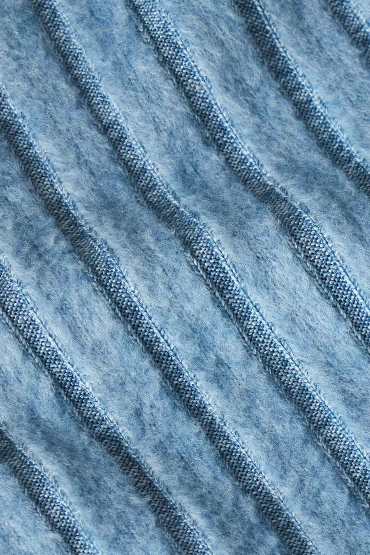 Close-up of textured blue fabric with a ribbed pattern