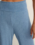 Close-up of blue ribbed pants on a neutral background