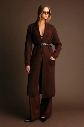 Woman wearing a brown coat against a dark background