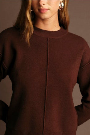 Brown sweater worn by a person against a neutral background