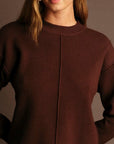 Brown sweater worn by a person against a neutral background