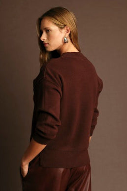 Woman wearing a brown outfit against a matching background