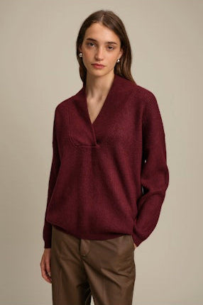 Woman wearing a burgundy sweater against a beige background