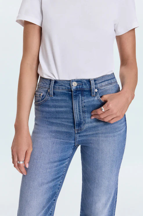 Person wearing blue jeans and a white t-shirt on a light gray background