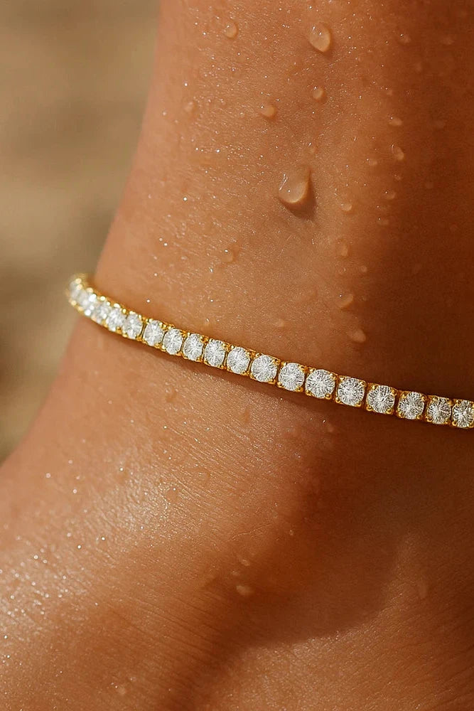 Gold bracelet with diamonds on a wrist with water droplets