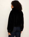 Person wearing a black fluffy sweater against a white background