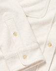 Close-up of a white shirt with gold buttons on a light background