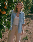 Woman standing in an orchard with orange trees