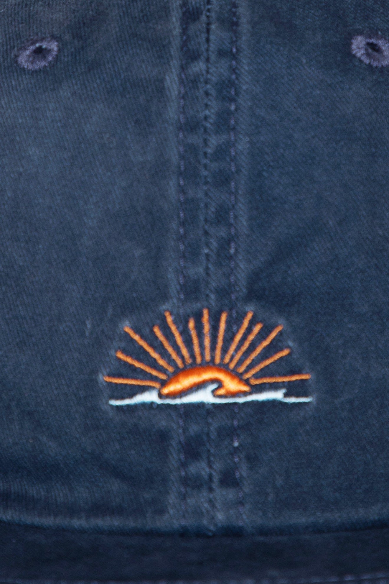 Navy blue cap with an embroidered logo featuring a sun and wave design.