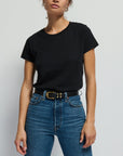 Person wearing a black t-shirt and blue jeans against a plain background