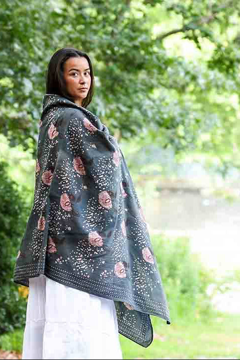 Woman wearing a dark green floral-patterned shawl in a park setting