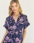 Woman wearing a purple floral dress on a white background