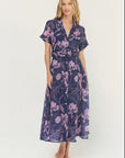 Woman wearing a purple floral dress on a white background