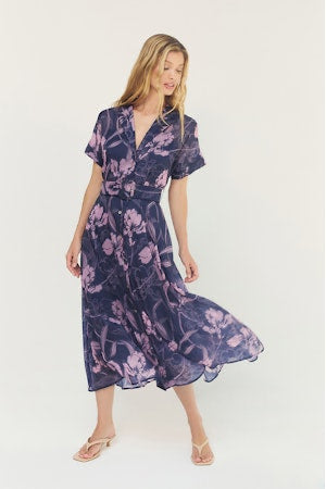 Woman wearing a purple floral dress on a white background
