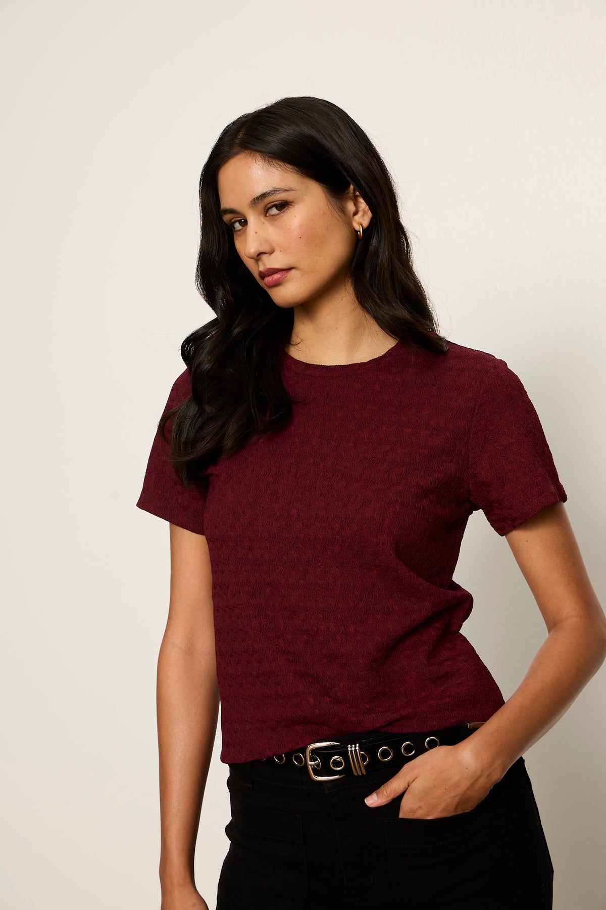 Woman wearing a maroon t-shirt against a plain background