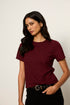 Woman wearing a maroon t-shirt against a plain background
