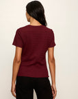 Person wearing a maroon t-shirt on a plain background
