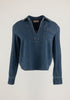 A dark blue denim long-sleeve shirt with a split V-neck, buttoned collar, and a chest pocket, shown against a plain white background.