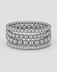 Stack of silver beaded bracelets on a white background