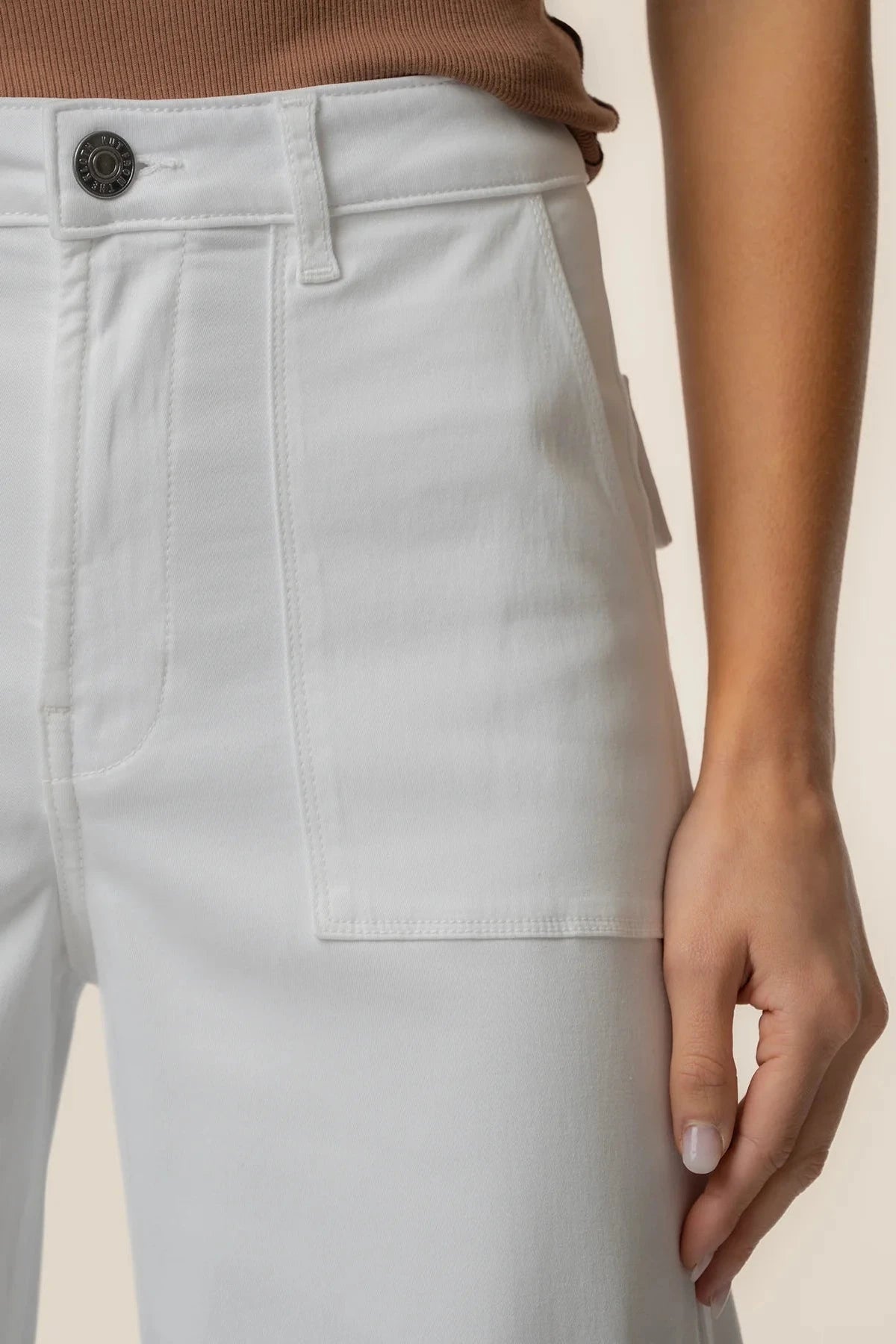 Light gray pants with a button detail on a neutral background