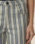Close-up of a person wearing striped pants with a neutral background