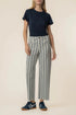 Person wearing a navy t-shirt and striped pants on a beige background