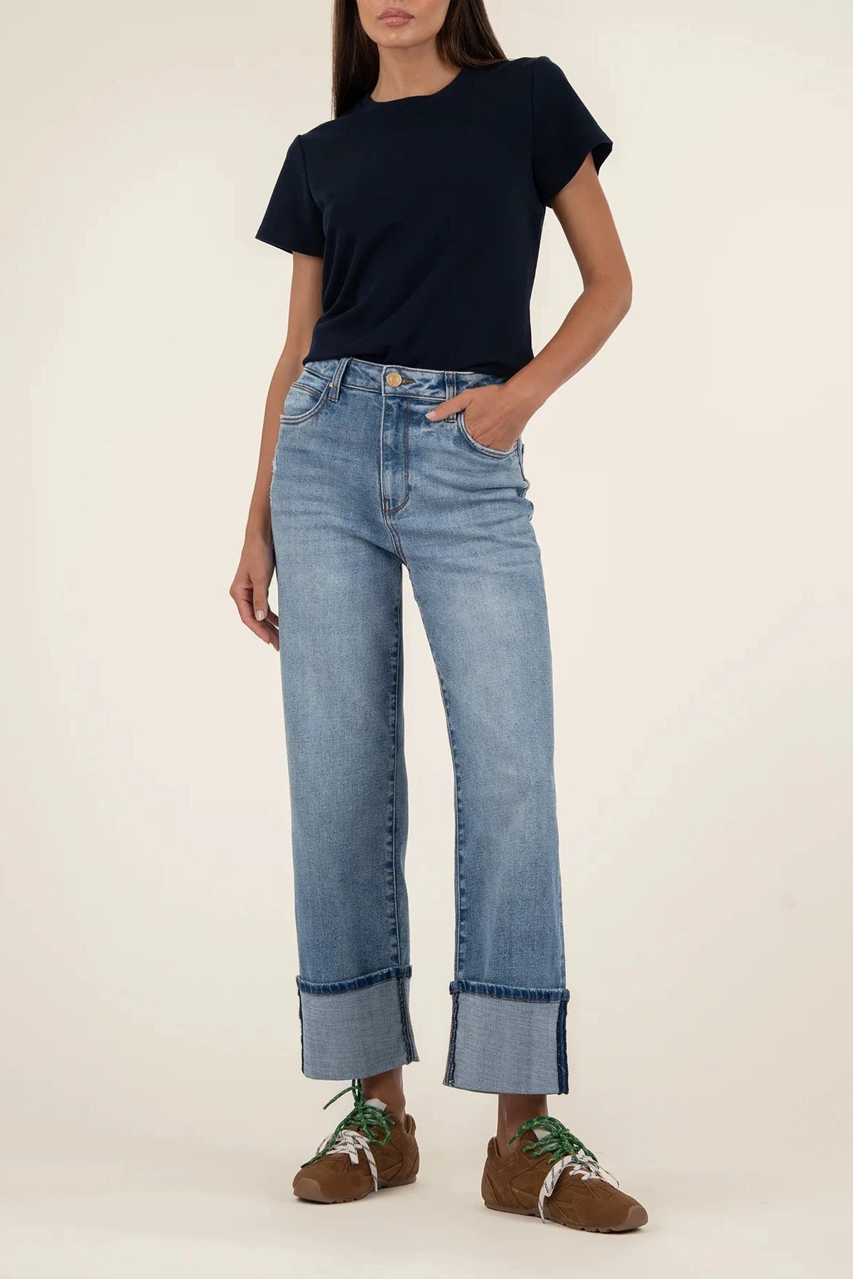 Person wearing a navy t-shirt and blue jeans on a plain background