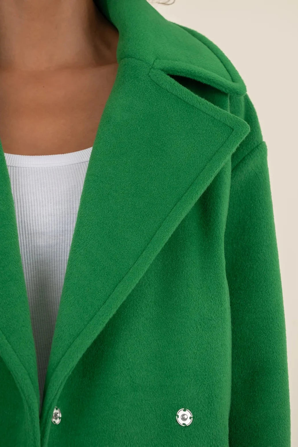 Green coat with a neutral background