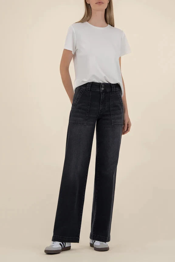 Person wearing a white t-shirt and black jeans on a beige background