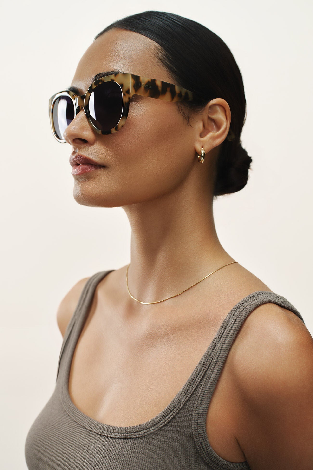 Woman wearing sunglasses with a neutral background